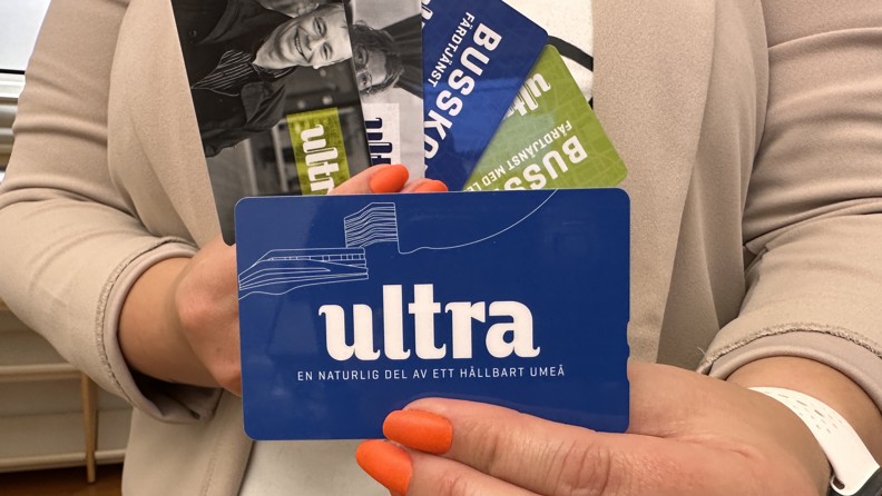 Kvinna visar nytt busskort, gamla kort i bakgrunden